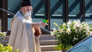 Nu e glumă! Preoții au împrăștiat aghiasmă credincioșilor printr-un pistol de jucărie, pentru a păstra distanța corespunzătoare. FOTO