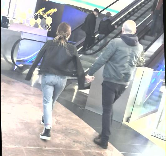 Se îndreaptă spre scara rulantă, care-i duce la etaj
