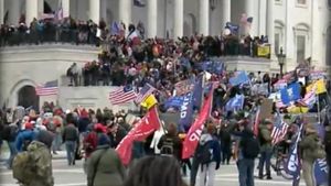 Steagul României, cu gaură la mijloc, precum la Revoluție, fluturat în mulțimea de la Capitoliu