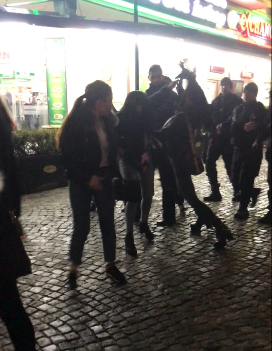 Una dintre tinere o lovește, din senin, pe o fată dintr-un grup