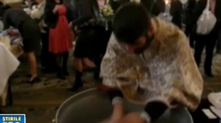 VIDEO Preot acuzat de tentativa de omor, dupa ce era sa inece o fetita in cristelnita, la botez!