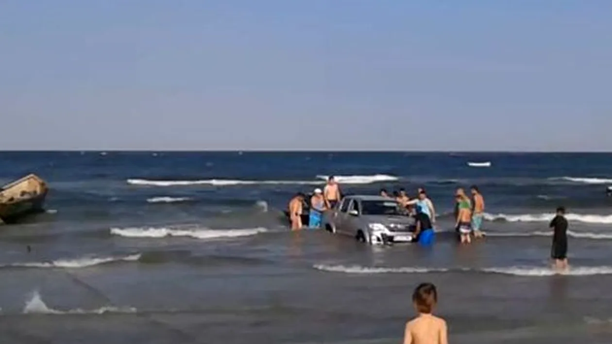 Situatie incredibila pe litoral! 15 oameni s-au chinuit sa scoata un jeep din mare!