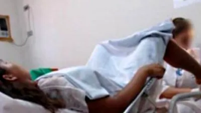 O femeie, la ginecolog, se așază, desface picioarele și le pune pe stativ. Doctorul îi spune: 'Mai sus!'