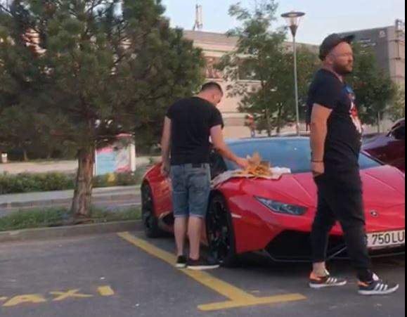 Cei doi înfulecă de pe capota unui Lamborghini roșu