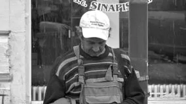 Fotografie emoționantă. Ce scrie pe șapca acestui bărbat din Iași, care ține, trist, în mână, o bancnotă de 1 leu
