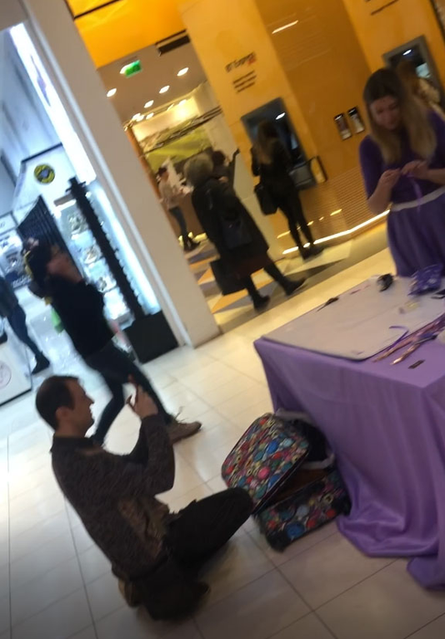 Aflat la mall, Călin Geambașu s-a pus în genunchi în fața unei hostese, pe care, la un moment dat, a și fotografiat-o