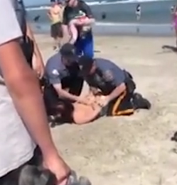 O femeie a fost ruptă cu bătaia de polițiști, pe plajă. Imagini halucinante