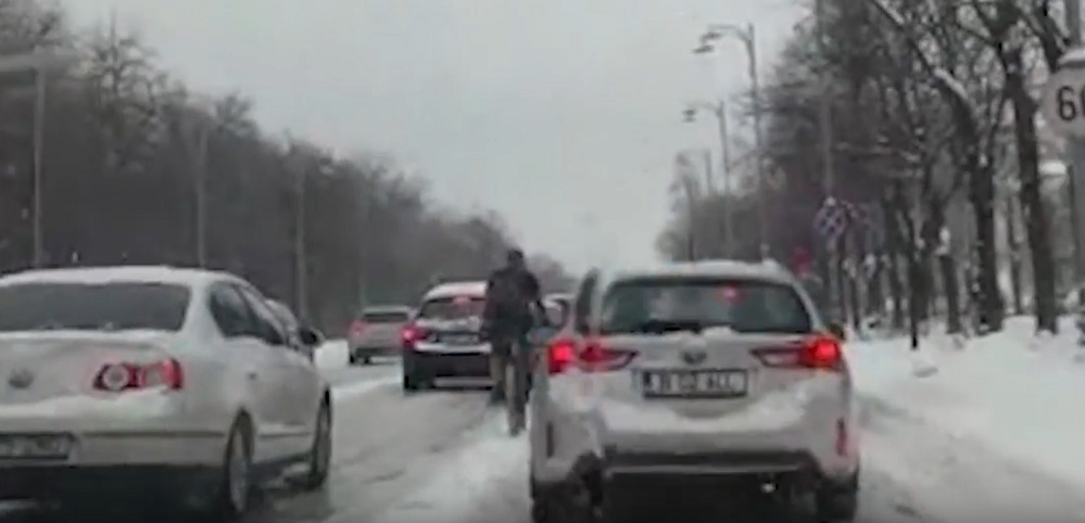 Un biciclist a făcut furori pe străzile troienite din București! Cum s-a îmbrăcat acesta, deși Capitala e sub cod portocaliu de ninsori viscol
