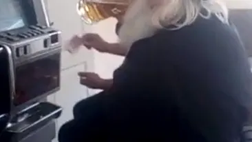 Un preot din Botoșani, filmat la păcănele în timp ce juca și dădea o bere pe gât: „Crucea mamii lui de aparat!”