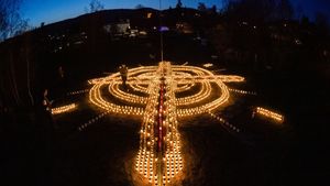 Gest emoționant în memoria victimelor răpuse de virusul  Covid-19! O femeie din Germania a făcut o cruce uriașă din candele, în curtea sa