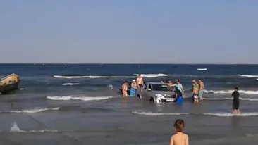 Situatie incredibila pe litoral! 15 oameni s-au chinuit sa scoata un jeep din mare!