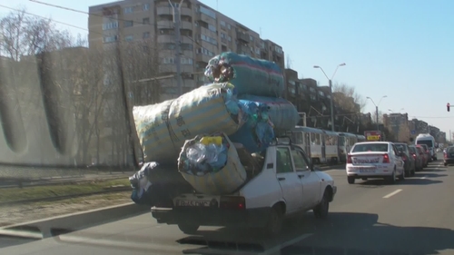 Parca ar fi Familia Flinstone! Se plimba prin Bucuresti cu “baloti” de sticle intr-o Dacie din alta epoca!