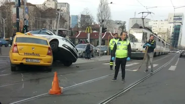VIDEO / Accident spectaculos în Bucureşti! O maşină de poliţie s-a ciocnit violent cu un taxi, pe care l-a strivit