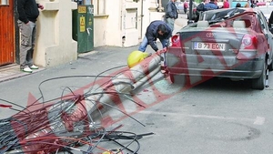 Masina avariata de un stalp care a cazut peste ea