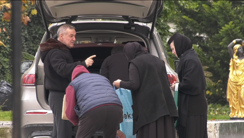 Gigi Becali, înconjurat de măicuțe, lângă portbagajul plin al mașinii sale (Foto: CANCAN.RO)