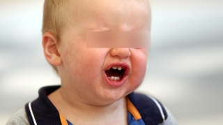 VIDEO Inuman! Un copil de un an a fost ars de mama sa cu un cutit incins
