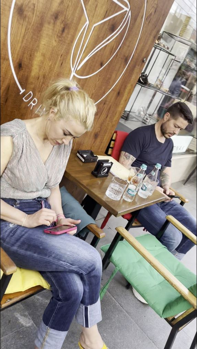 Jorge și soția lui, Ramona, stau pe telefoane, la o terasă din Calea Victoriei (Foto: CANCAN.RO)