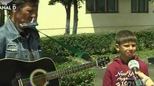VIDEO De Ziua Copiilor, pustiul de la "Romanii au talent" a iesit in strada sa cante  la fluier pentru a le lua paine celor 11 frati! Uite cum il asteapta acasa!