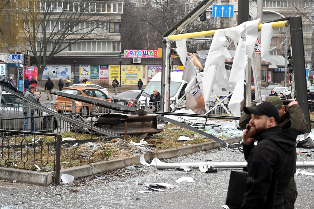 Poliția și personalul de securitate inspectează zona unde a explodat un obuz, pe o stradă din Kiev la 24 februarie 2022. (Sursa foto: profimedia.ro)
