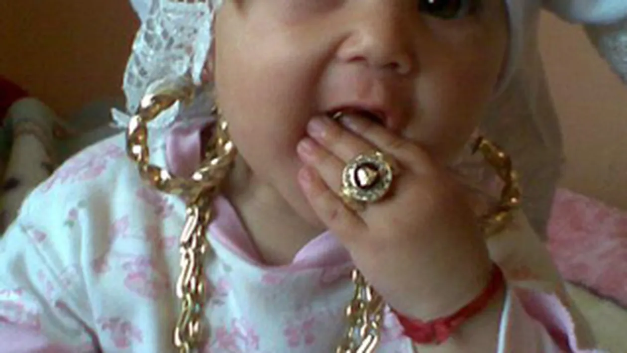 Imaginea de 24 de carate! Fetita asta de doar cativa anisori e BLINDATA de aur - O trag in jos cerceii si ghiulul, iar dintisorii ei nu sunt de lapte, sunt de AUR!