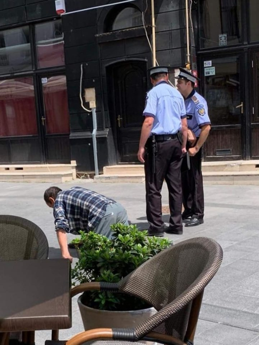 Polițiștii locali nu îl bagă în seamă pe bărbatul care se târăște pe lângă ei