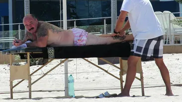 Filmările care vor scrie istorie pe Facebook. Temutul Nuţu Cămătaru, ”frământat” pe plajă de un domn cu mânuţe fine!