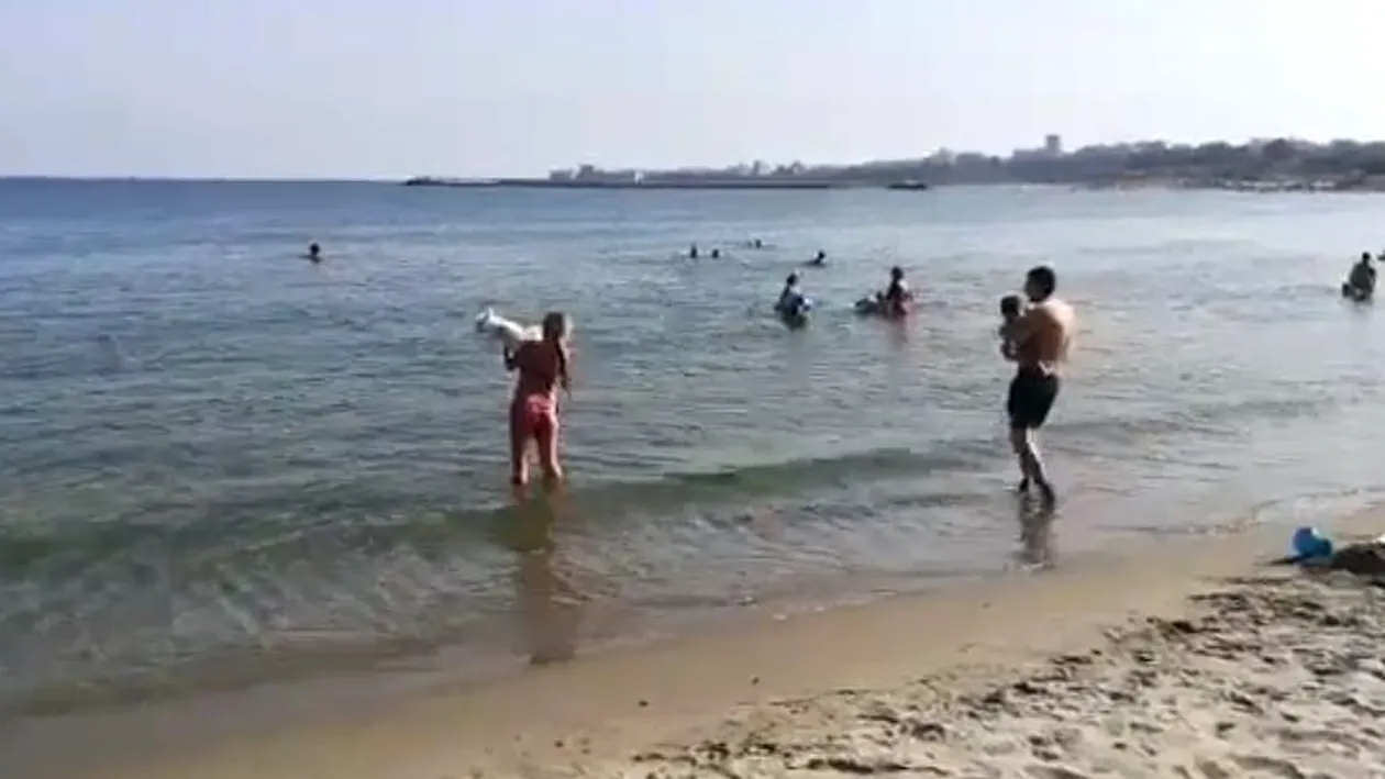 Tânără, surprinsă în timp ce-și curăța câinele de excremente în apa mării, după ce animalul și-a făcut nevoile pe plajă!