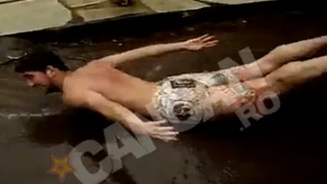 VIDEO Distractie de dementi! Un dobitoc se crede peste si se zbate pe trotuar intr-o balta