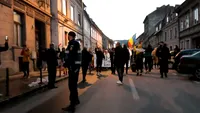 Imaginea zilei vine de la Brașov. Un bolnav de COVID, cu masca de oxigen pe față, privește pe geam protestele din stradă. FOTO