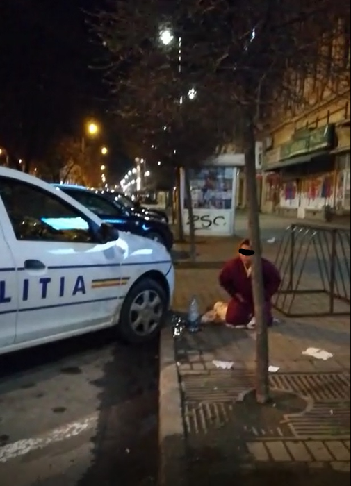 Femeia așteaptă să fie urcată în ambulanță