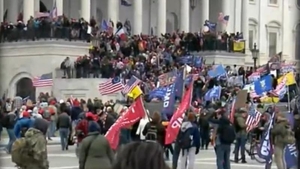 Steagul României, cu gaură la mijloc, precum la Revoluție, fluturat în mulțimea de la Capitoliu