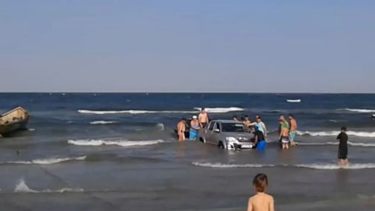 Situatie incredibila pe litoral! 15 oameni s-au chinuit sa scoata un jeep din mare!