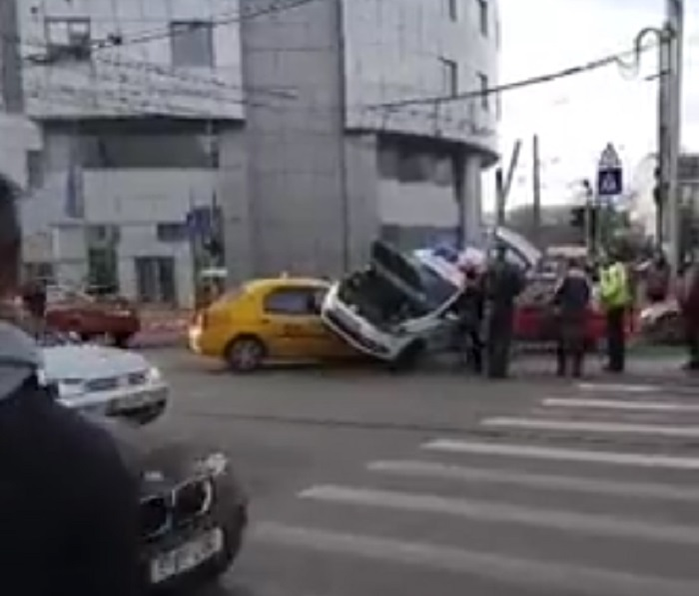 VIDEO / Accident spectaculos în Bucureşti! O maşină de poliţie s-a ciocnit violent cu un taxi, pe care l-a strivit