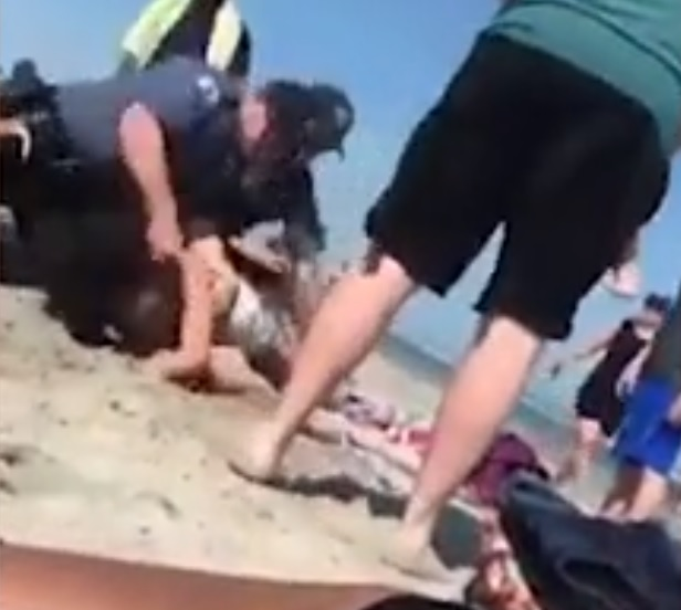 O femeie a fost ruptă cu bătaia de polițiști, pe plajă. Imagini halucinante