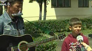 VIDEO De Ziua Copiilor, pustiul de la "Romanii au talent" a iesit in strada sa cante  la fluier pentru a le lua paine celor 11 frati! Uite cum il asteapta acasa!