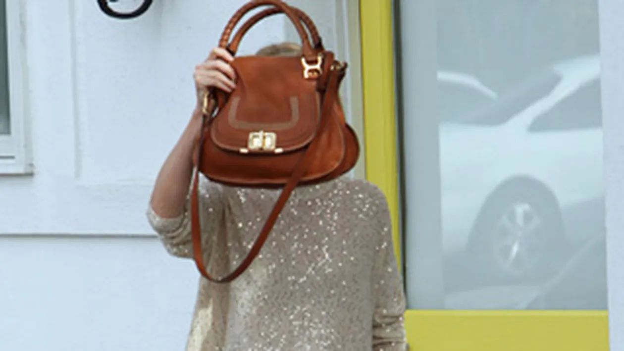 Blonda, sexy si faimoasa! Ghici cine se ascunde in spatele posetei?