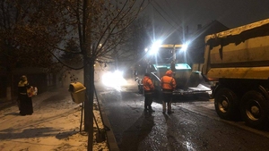 Nici vremea rea nu-i împiedică pe drumari! La Craiova se asfaltează pe ninsoare