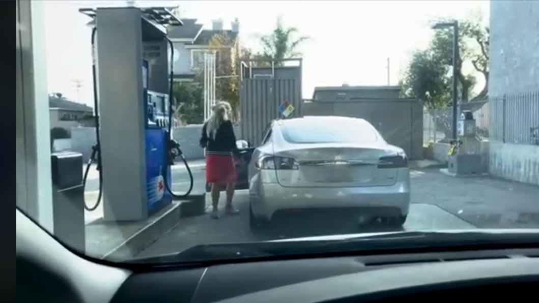 Te tăvălești de râs! O blondă vrea să bage benzină, deși mașina e electrică! Ce i-au făcut doi tineri aflați în spatele ei VIDEO
