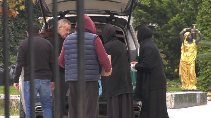 Gigi Becali, înconjurat de măicuțe, lângă portbagajul plin al mașinii sale (Foto: CANCAN.RO)