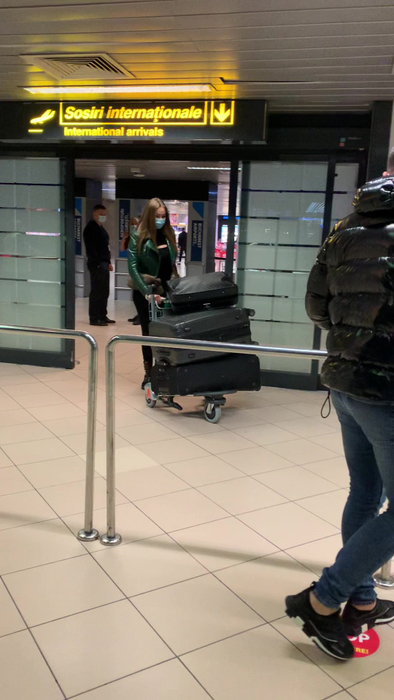 Daria Radionova, împinge un cărucior plin de bagaja, pe aeroportul Otopeni