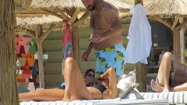 VIDEO EXCLUSIV. Soţia a dispărut din peisaj, iar el… Milionarul BLUE AIR, 
suspect de jucăuş cu o sexoasă la plajă!