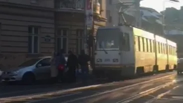 Această maşină a blocat o linie de tramvai din Capitală, iar trecătorii au pus umăr la umăr pentru a putea s-o dea la o parte. Imaginile sunt incredibile