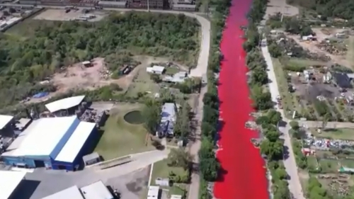 Alertă de mediu! Un râu a devenit roșu și răspândește un miros toxic. Localnicii s-au speriat