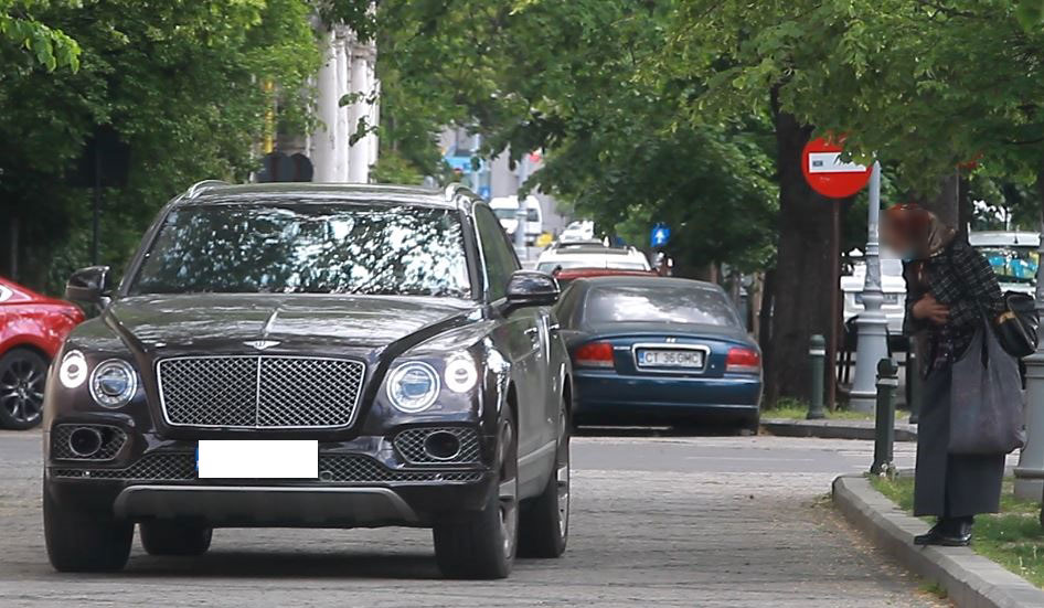 Femeia face o mică plecăciune când vede mașina lui Gigi Becali