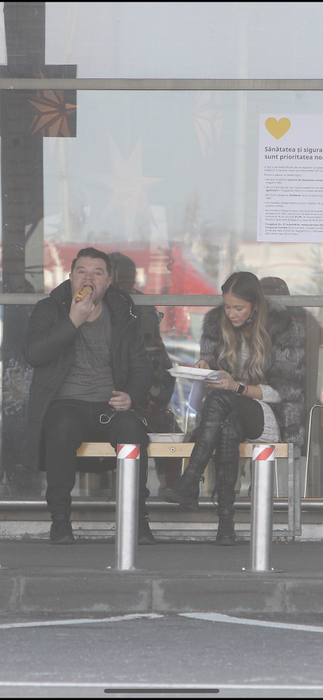 Andrei și Grațiela Duban înfulecă hotdog pe o bancă, la Ikea