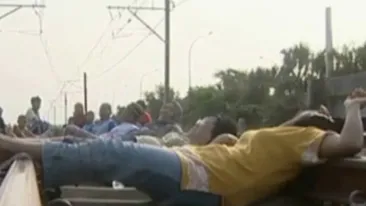 VIDEO Metoda barbara de tratament! Indonezienii se asaza pe liniile de tren, de-a latul, crezand ca se vindeca