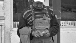 Fotografie emoționantă. Ce scrie pe șapca acestui bărbat din Iași, care ține, trist, în mână, o bancnotă de 1 leu