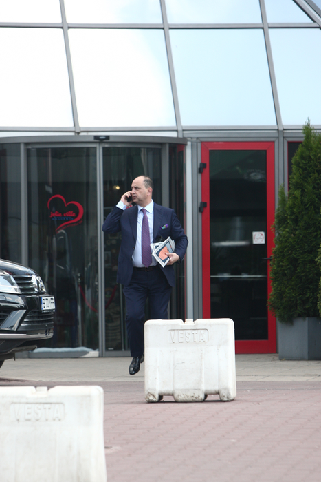 Comănescu vorbeşte la telefon în timp ce ţine somonul la subraţ