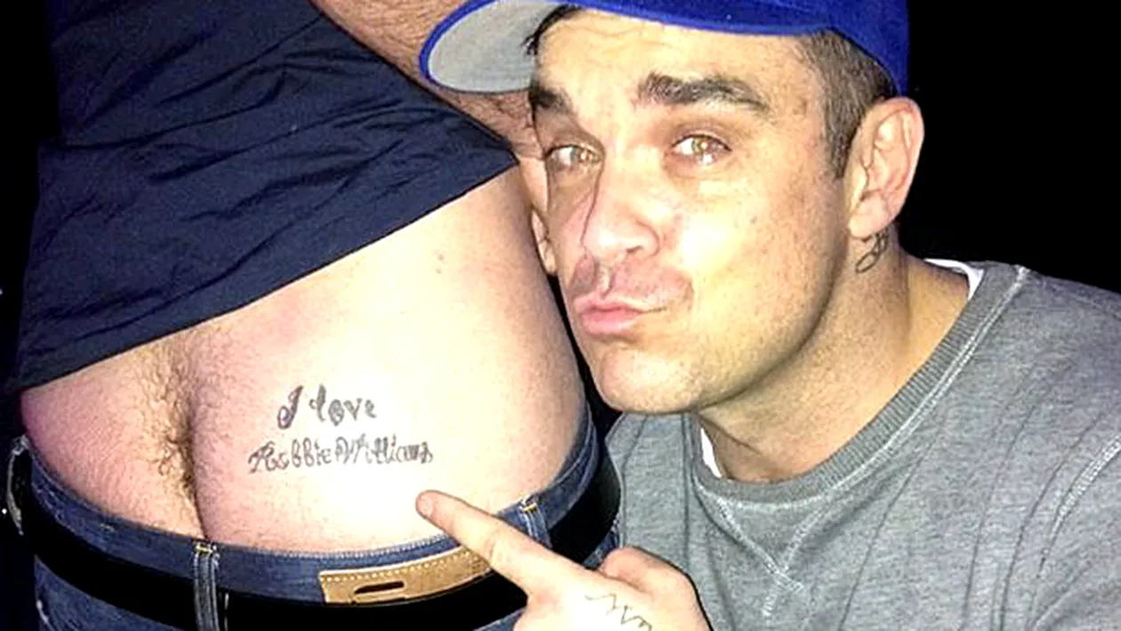 Un fan il trateaza cu fundul pe idolul lui, Robbie Williams. Mesajul de pe fesier i-a intrat la suflet artistului