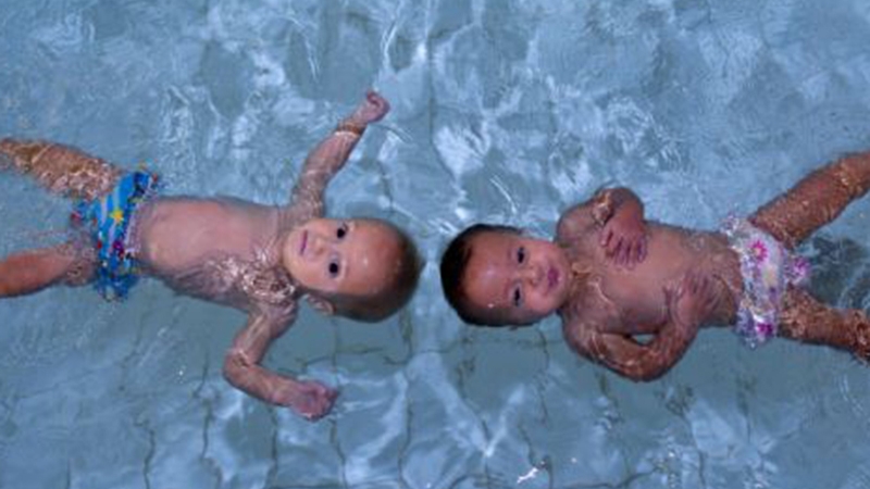 Bebeluşii acvatici! Faceţi cunoştinţă cu gemenii care sunt prea mici să meargă sau să vorbească, dar care înoată 25 m în piscină!